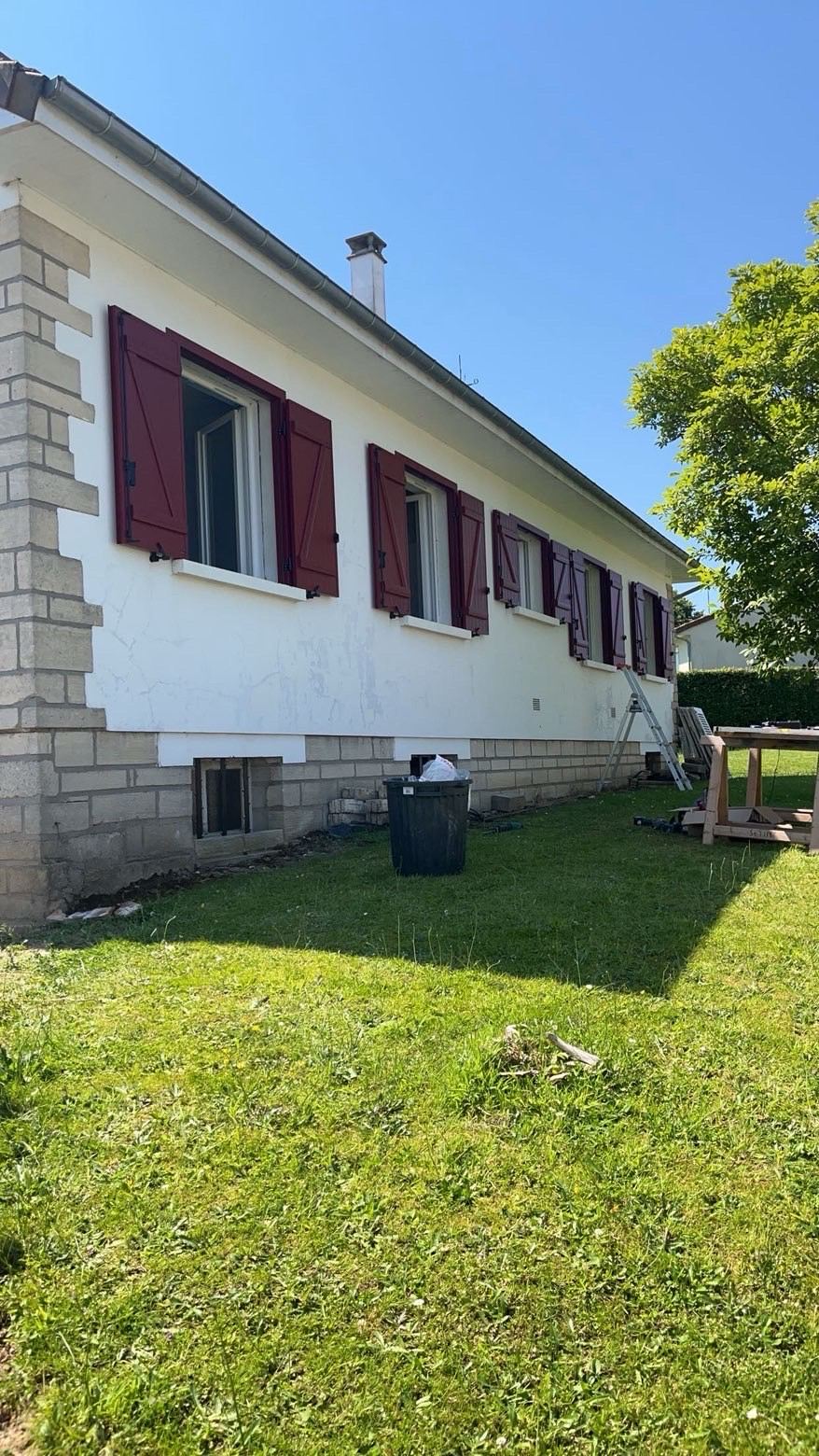 Façade de pavillon avec volets battants bordeaux, chantier de rénovation extérieure en cours